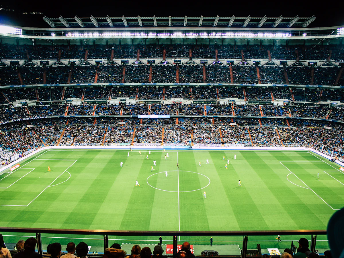 A packed football stadium under floodlights